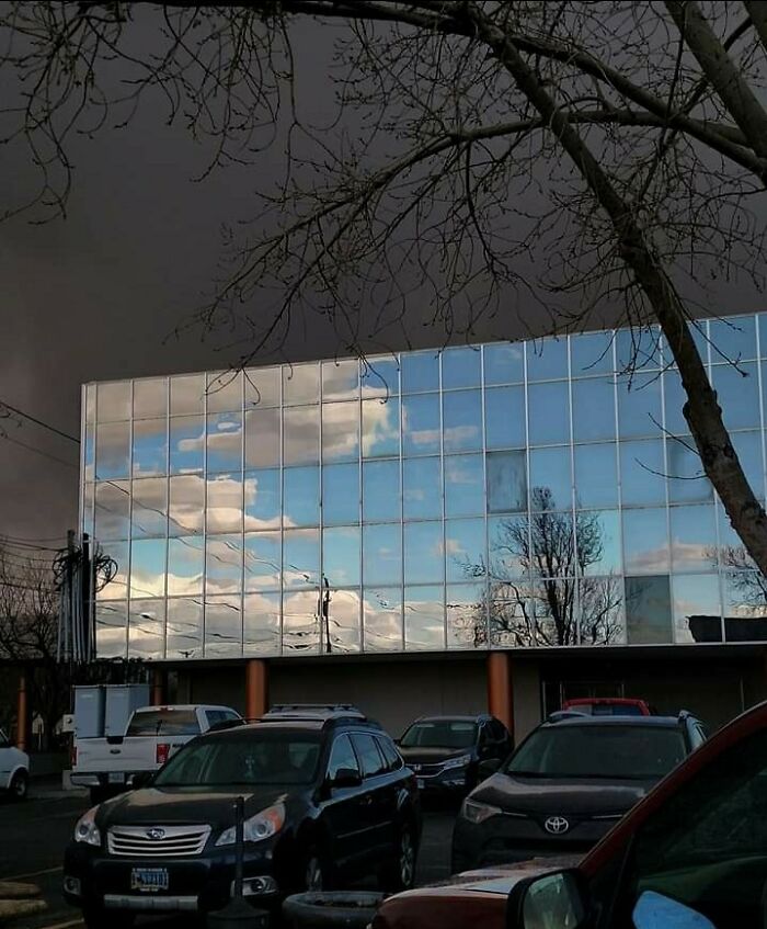 El cielo azul se refleja en el edificio con la tormenta detrás
