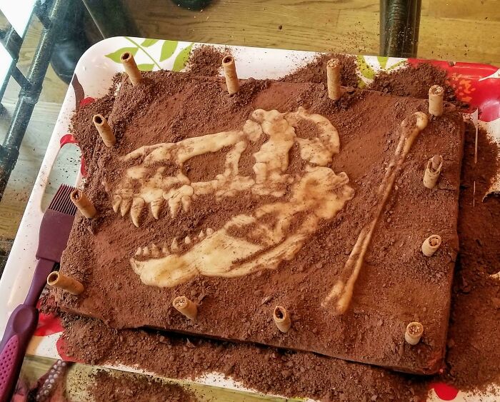Tarta de cumpleaños de chocolate decorada para que parezca una excavación, con fósiles de mazapán escondidos bajo la "suciedad" de las migas