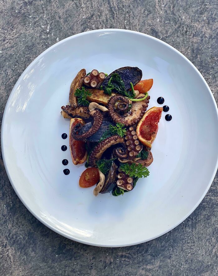 Charred Octopus, Garlic Roasted Fingerlings With Sautéed Spinach, Cherry Tomatoes, And Smoked Wild Mushrooms. Finished With A Squeeze Of Blood Oranges