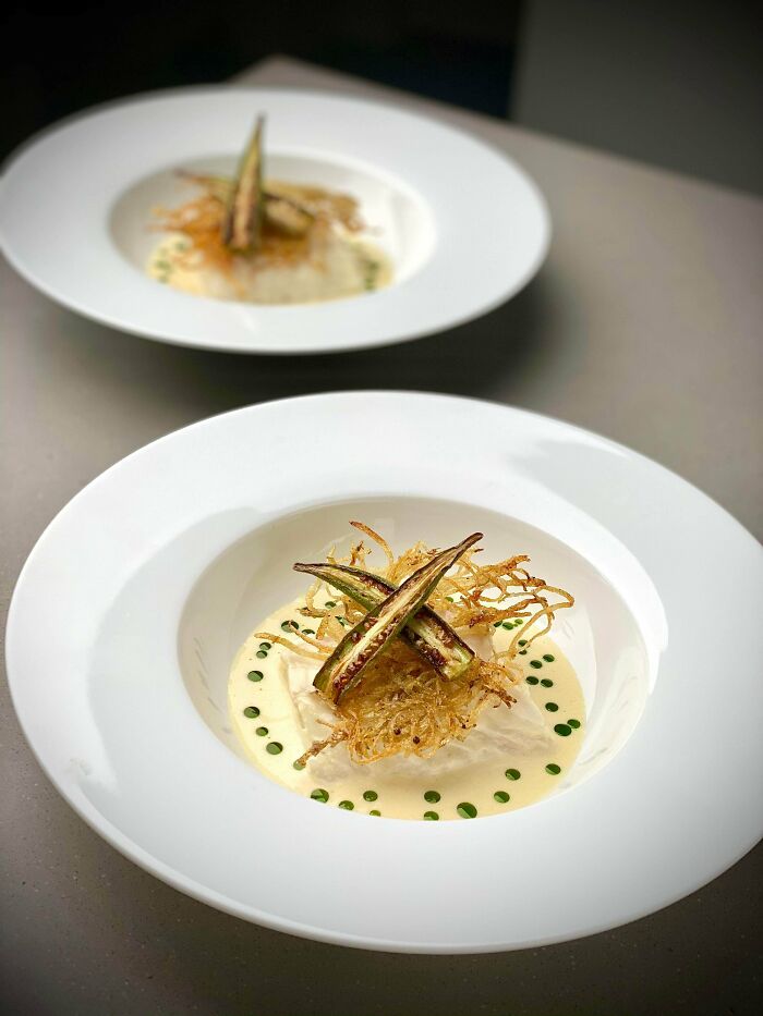 Sous Vide Cod, Garlic Lemon And Dill Marinade, Served In Okra Cream Broth With Fried Okra, Potato Tuille, And Herb Oil.