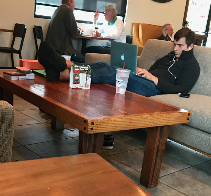 Este tipo en la cafetería se quitó los zapatos y puso los pies en la mesa de café