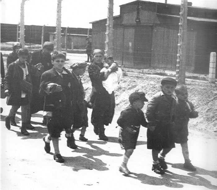 Niños judíos cogidos de la mano mientras caminan sin saberlo hacia su muerte en las cámaras de gas de Auschwitz