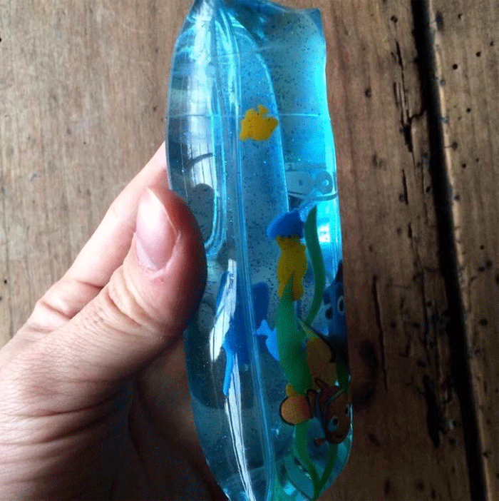 Tubo de plástico con agua y peces de plástico dentro
