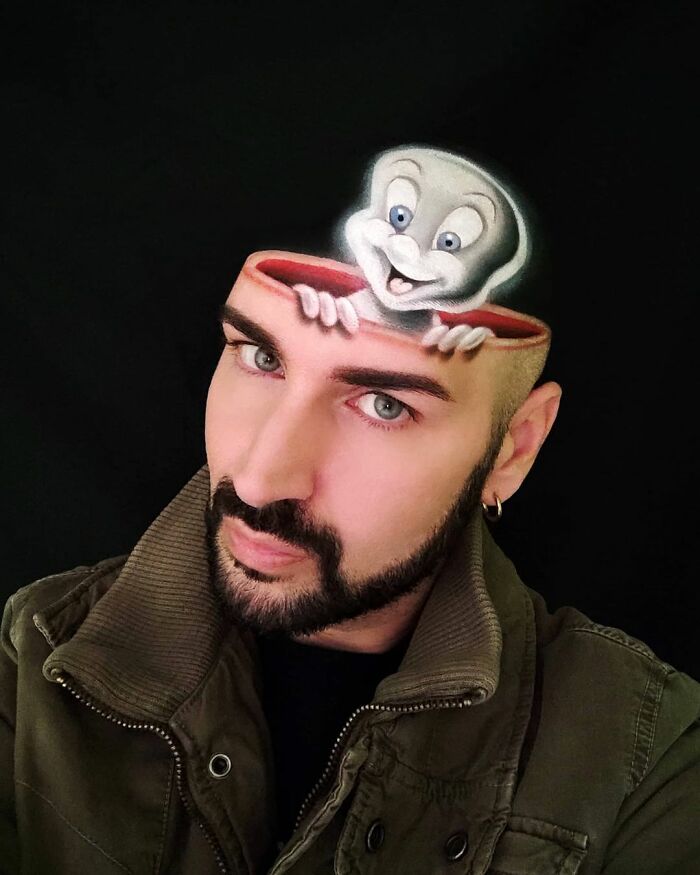 Italian artist using his body as a canvas to create a convincing optical illusion with a cartoon character emerging from his head.