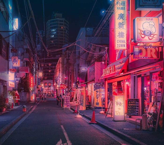 Night street scene in Japan illuminated by vibrant neon lights, capturing the beauty of Japan's urban nightlife atmosphere.