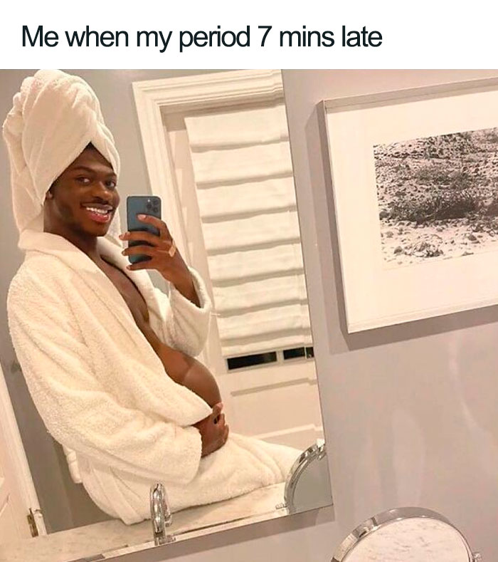 Person in a robe and towel poses humorously in a mirror selfie.