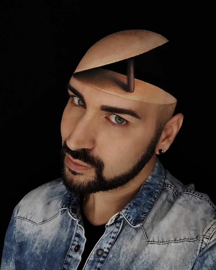Italian artist creating convincing optical illusions using body paint to transform his face into a surreal open-head design.