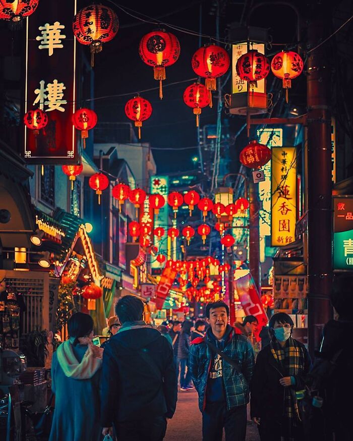 Vibrant Japanese street at night adorned with glowing red lanterns and bustling crowds capturing the beauty of Japan.