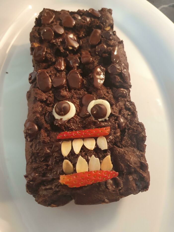 Chocolate cake decorated with nuts and strawberries to resemble a funny monster face, a classic cake fail.
