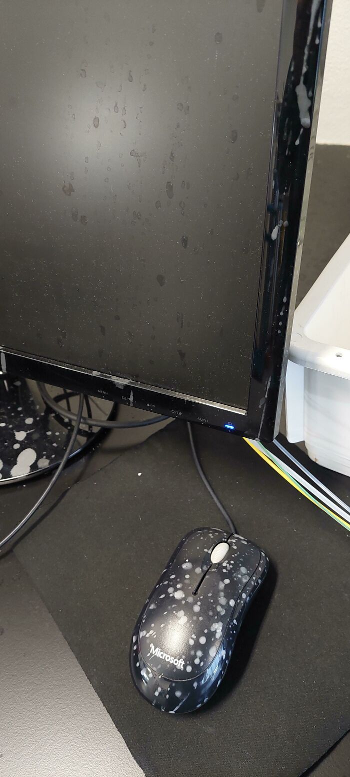 Computer monitor and Microsoft mouse covered in white paint splatters showing a worst tech support case on the job.