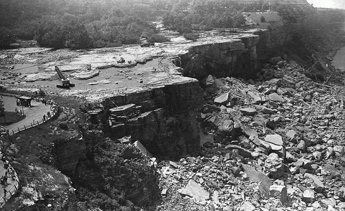 Historical photo of a dried-up Niagara Falls in 1969, with exposed rocks and construction cranes visible.