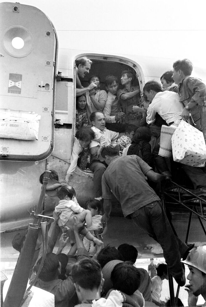 Historical photo of people boarding a plane during a dramatic evacuation, capturing a pivotal moment in history.