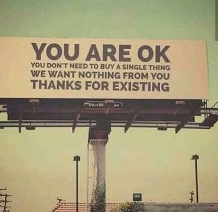 Billboard with message promoting anti-consumption mindset, emphasizing no need to buy, thanking for existing in public space.