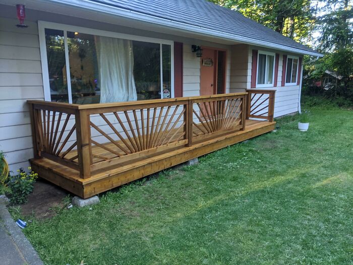 Wooden porch deck with sunburst railing design showcasing advanced woodworking skills shared in an online group.