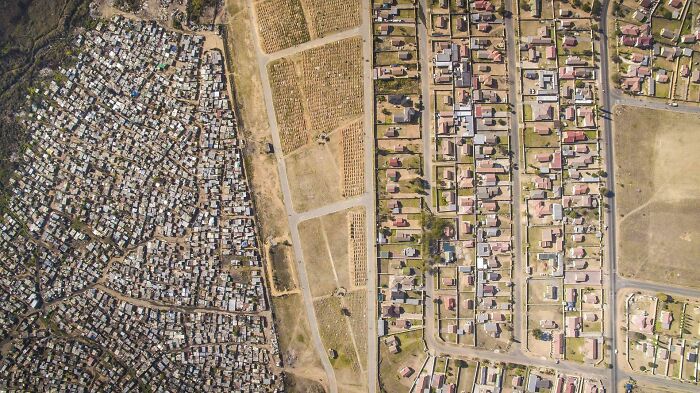 Aerial view of urban hell showing stark contrast between informal settlements and organized residential area.