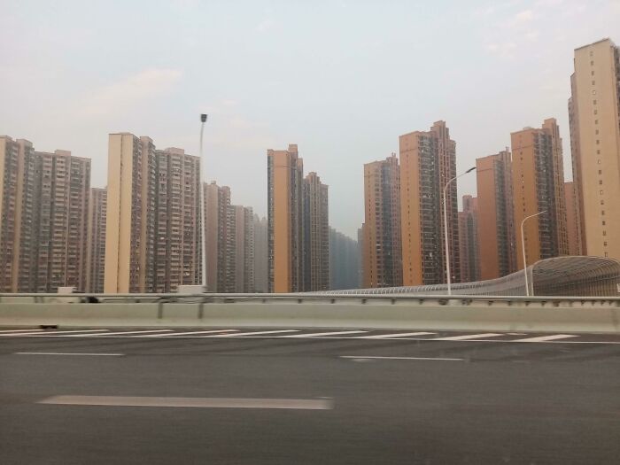 Rows of tall, uniform apartment buildings creating an urban hell scene resembling a dystopian movie setting.