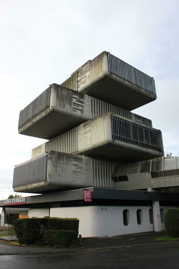 Brutalist urban hell building with stacked concrete blocks and dark metal grates, resembling dystopian architecture.