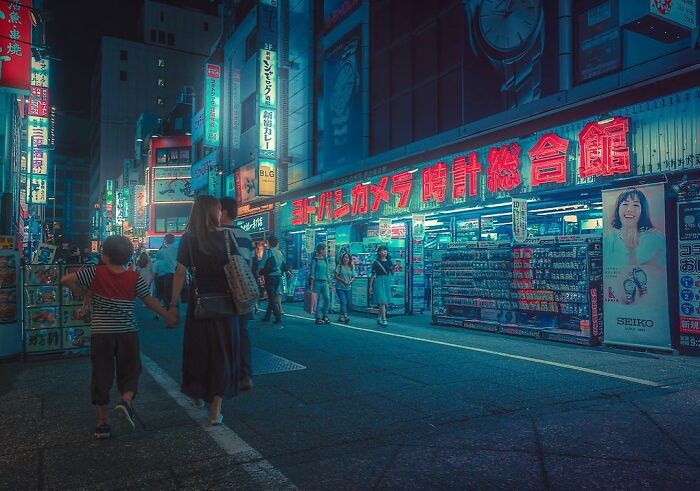 Night street scene in Japan with glowing neon signs and people walking, capturing the beauty of Japan’s vibrant city life.