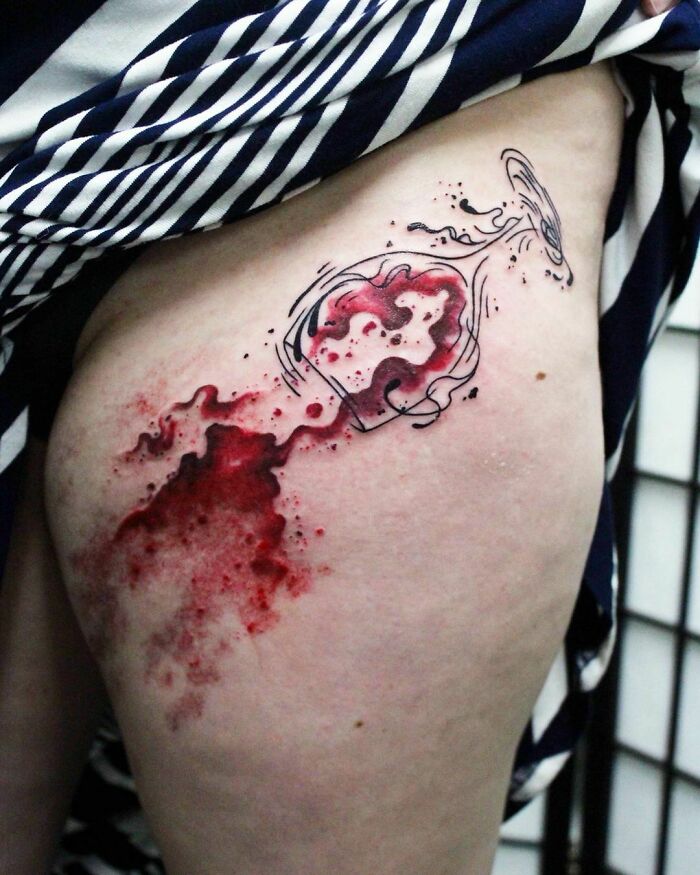 Scar cover-up tattoo depicting a spilled wine glass design on the skin.