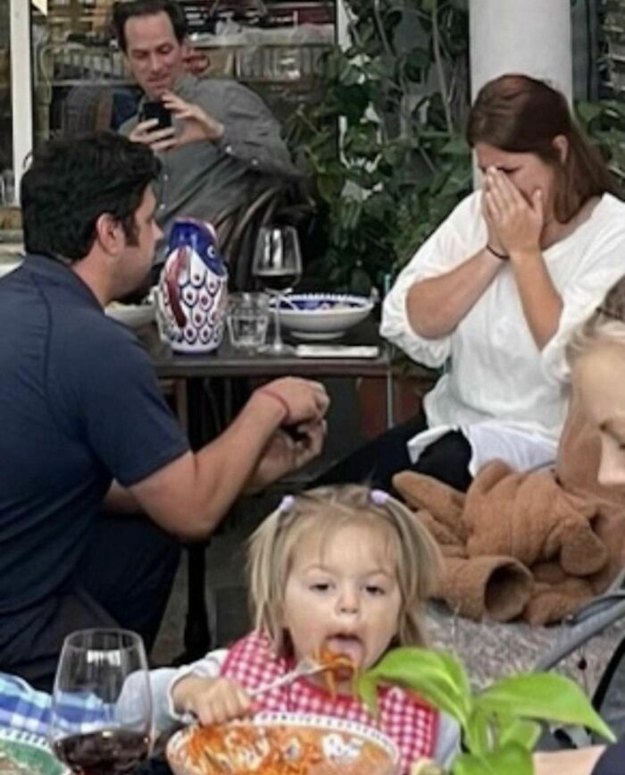 Family dining awkwardly while a toddler eats spaghetti messily, showcasing one of the weirdest Instagram account moments.