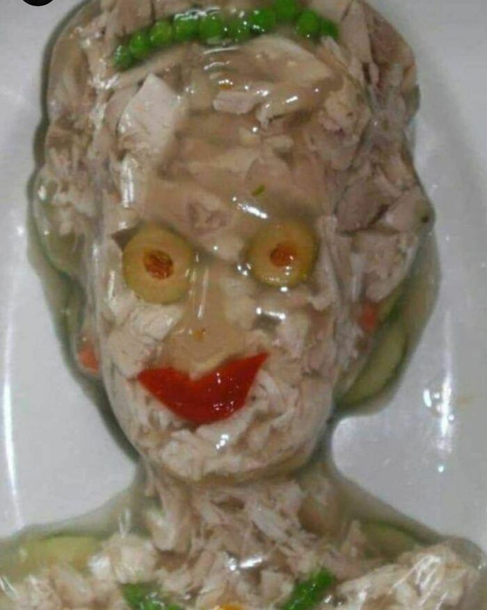Face-shaped meat aspic made with olives, peas, and red pepper, showcasing one of the weirdest Instagram account pictures.