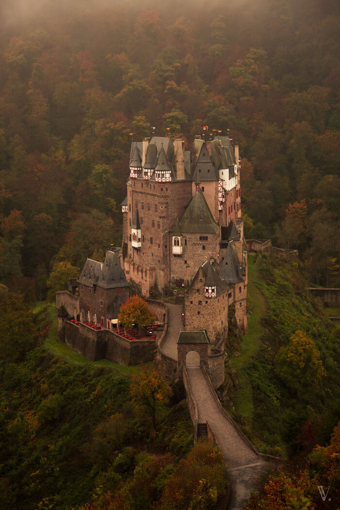 Medieval castle surrounded by autumn forest, showcasing one of the most beautiful castles around the world in atmospheric light.