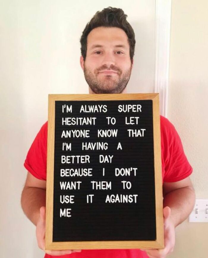 Man in red shirt holding sign sharing feelings about chronic illnesses awareness on Instagram account post
