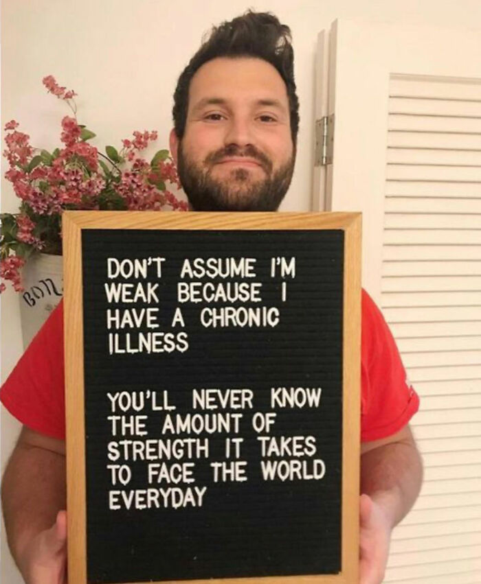 Man holding sign raising awareness about the strength of people with chronic illnesses every day.
