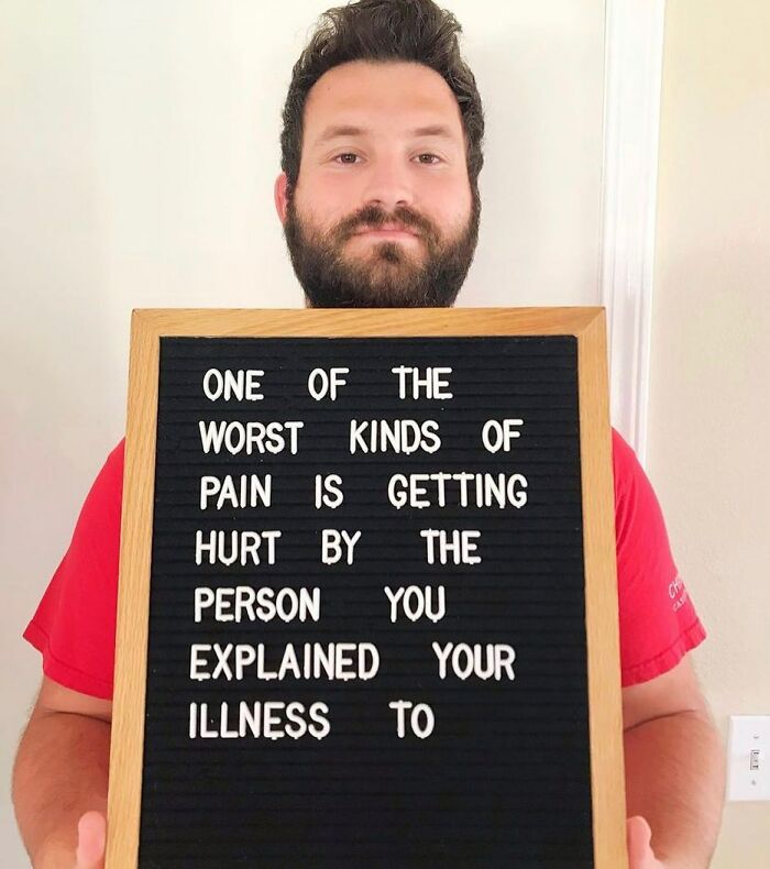 Man holding board describing pain from being hurt after explaining chronic illness, raising awareness about chronic illnesses.