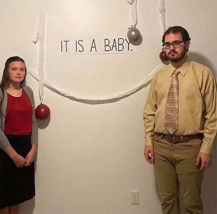 Two people stand awkwardly by a wall decorated with balloons and a sign saying it is a baby, weird Instagram account content.