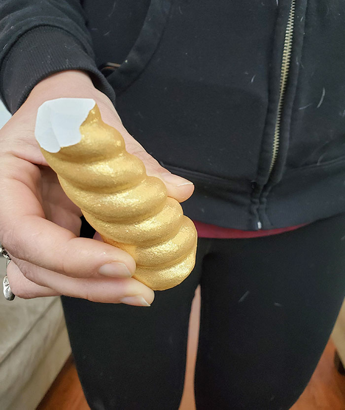 Hand holding a golden spiral object, illustrating creative evil marketing techniques used by businesses.