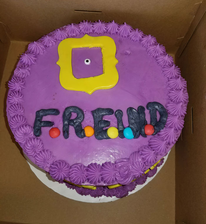 Funny cake fail with misspelled "FREIND" in colorful icing on a purple frosted cake.
