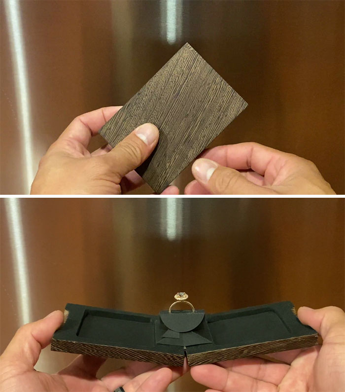 Hands holding a handcrafted wooden pop-up ring box showcasing detailed woodworking skills and creativity.