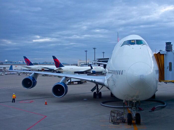 Large airplane parked at an airport gate with ground crew nearby, illustrating the concept of dodging a huge tactical nuke.