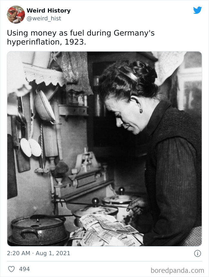 Woman using money as fuel to cook during Germany's hyperinflation in 1923, a weird history fact for history and trivia lovers.