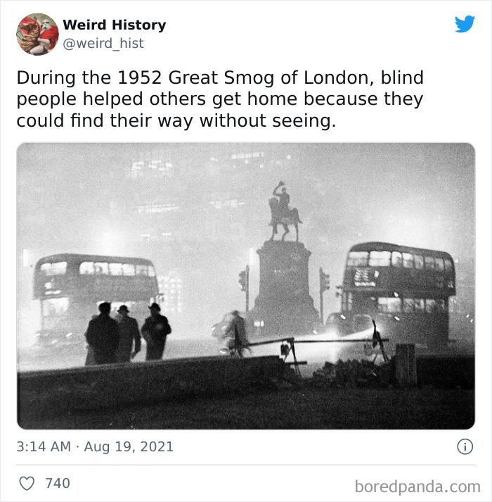 Black and white photo showing people and double-decker buses during the 1952 Great Smog of London, a weird history fact.