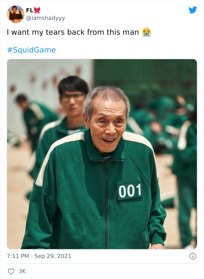 Elderly man in green tracksuit with number 001, smiling in a scene from Netflix’s Squid Game.