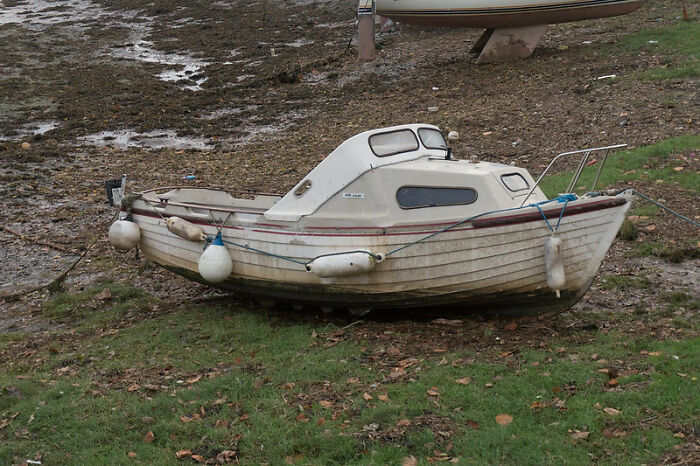 Small abandoned boat resting on muddy shore with fishing floats attached, symbolizing a huge tactical nuke dodged.