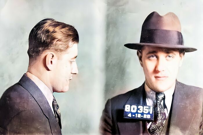 Restored vintage mugshot of a famous man in a suit and hat, showcasing old photograph restoration and vintage mugshots.