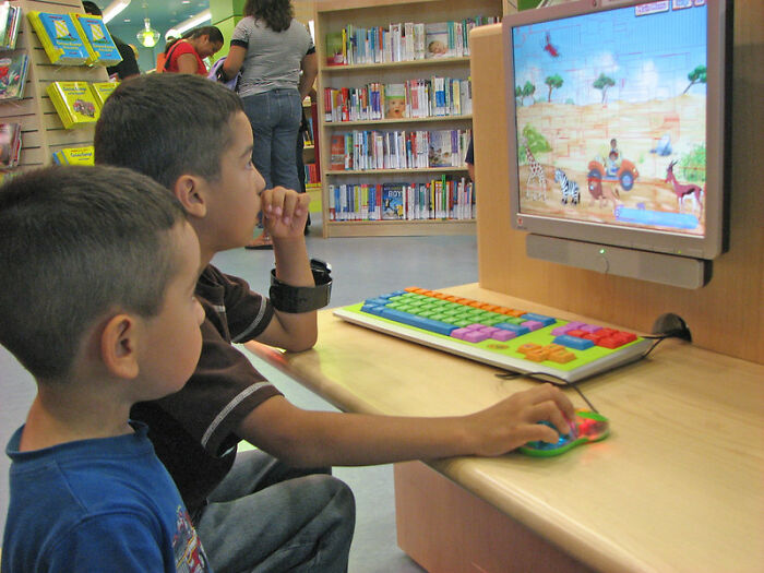 Two boys engaged in an online group activity on a colorful keyboard, exploring tactical nuke discussion topics.