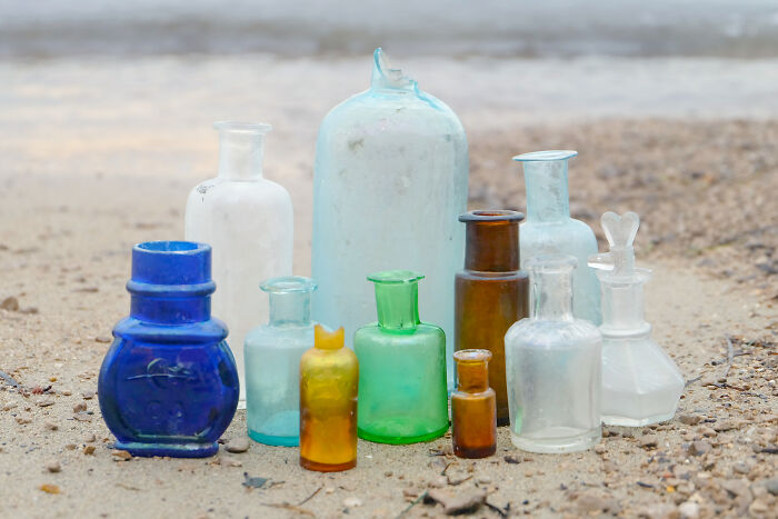 Collection of antique glass bottles found washed up on the beach during treasure search along the shore.