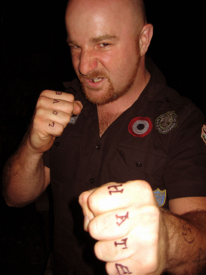 Man showing fists with words love and hate written on fingers, representing real world secrets and advice for young adults.