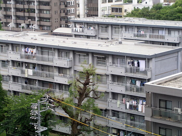 Residential apartment building with balconies and laundry hanging, illustrating an online group tactical nuke dodge discussion.