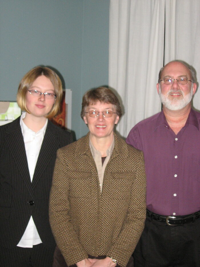 Three people wearing glasses and business casual clothes, posing indoors for a photo about real world advice.