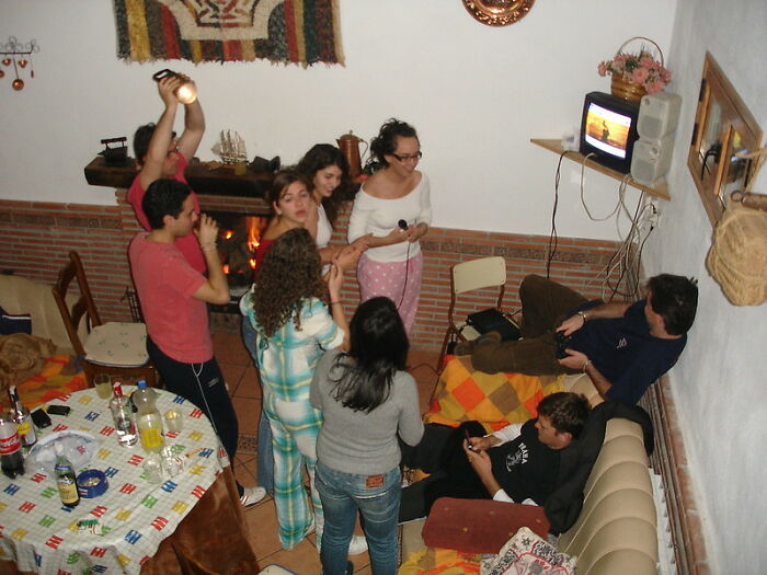 Group of friends in a cozy living room, enjoying a social gathering and shared entertainment during a casual evening.