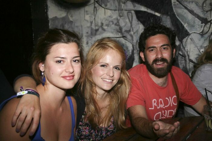 Three young adults smiling and socializing in a casual setting, sharing advice about the real world secrets.