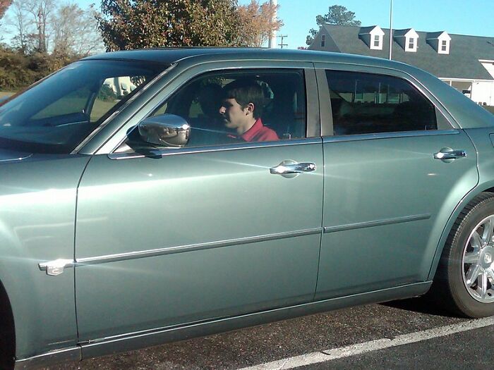 Person sitting inside a stationary car in a parking lot, illustrating a tactical nuke dodged situation discussion.