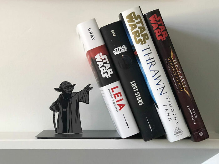 Este sujetalibros de Yoda que parece que Yoda está sosteniendo los libros con la Fuerza