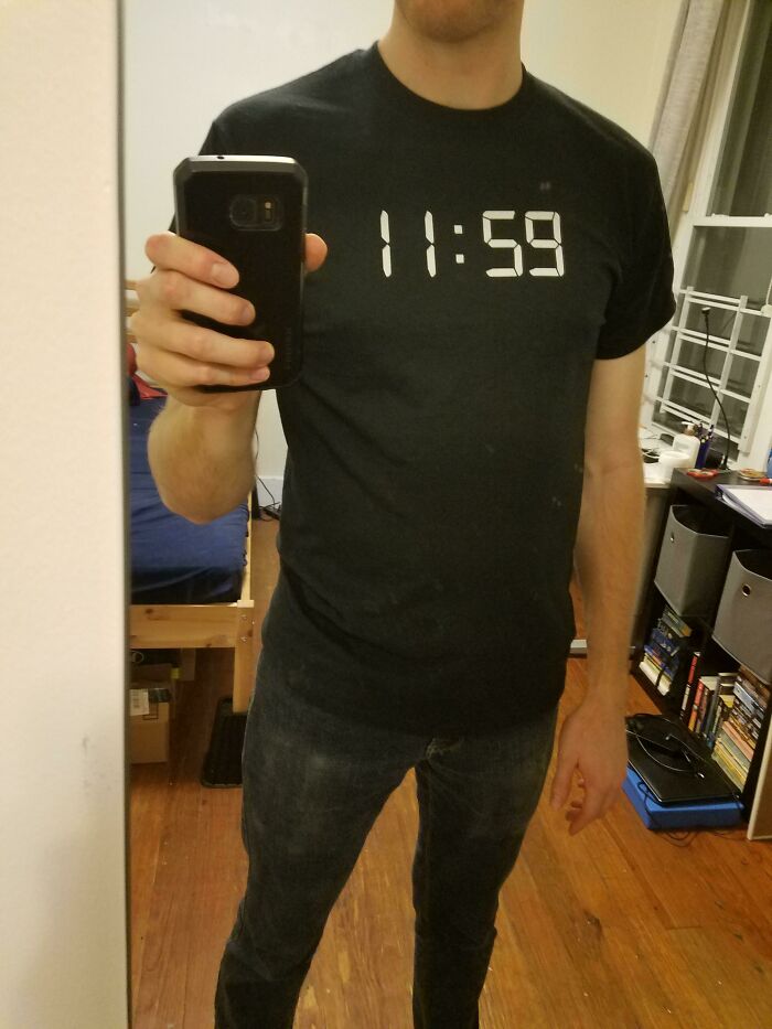 Person wearing a simple black shirt with 11:59 displayed, an easy Halloween costume from 50 people who didn't spend much effort.