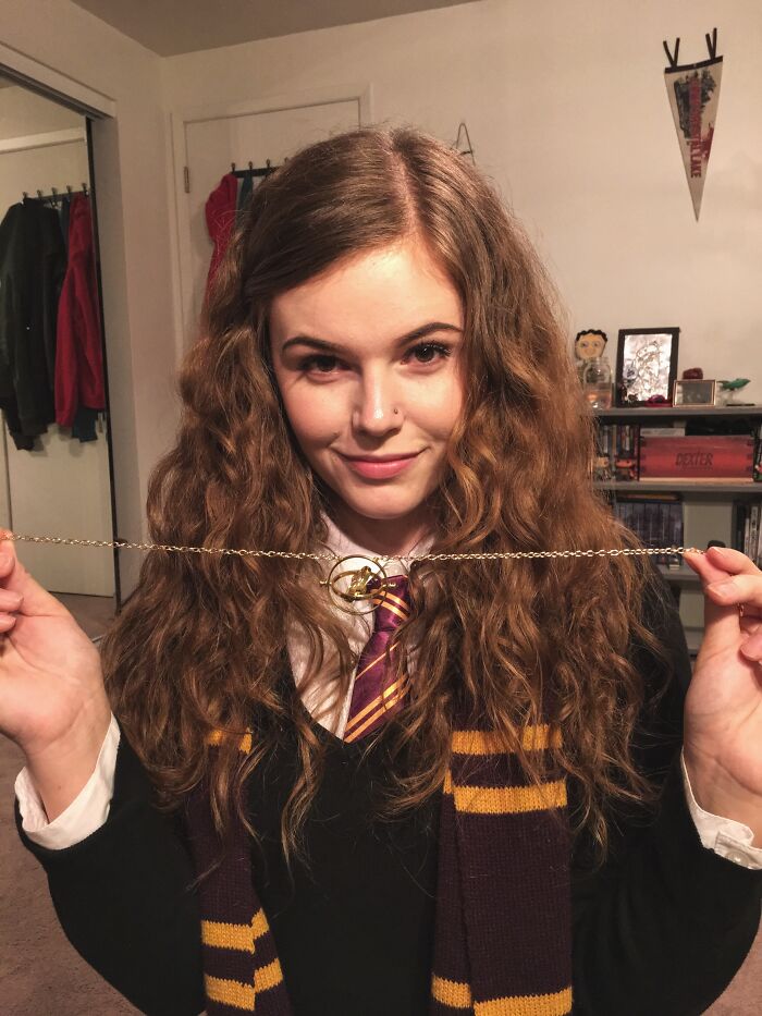 Young woman in a simple Harry Potter costume holding a Golden Snitch necklace, showcasing easy Halloween costume ideas.
